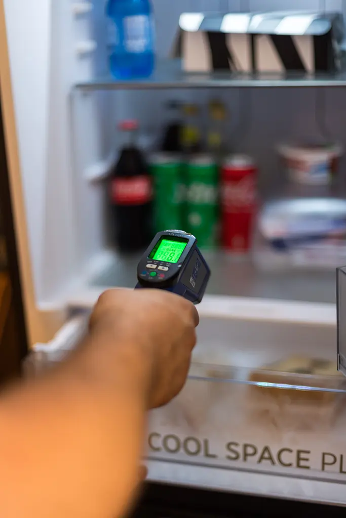 Tecnico controlla temperatura frigorifero